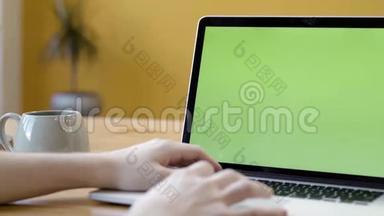 自由职业者坐在笔记本电脑上的特写，绿色屏幕。 库存录像。 男人用绿色屏幕在笔记本电脑上打字